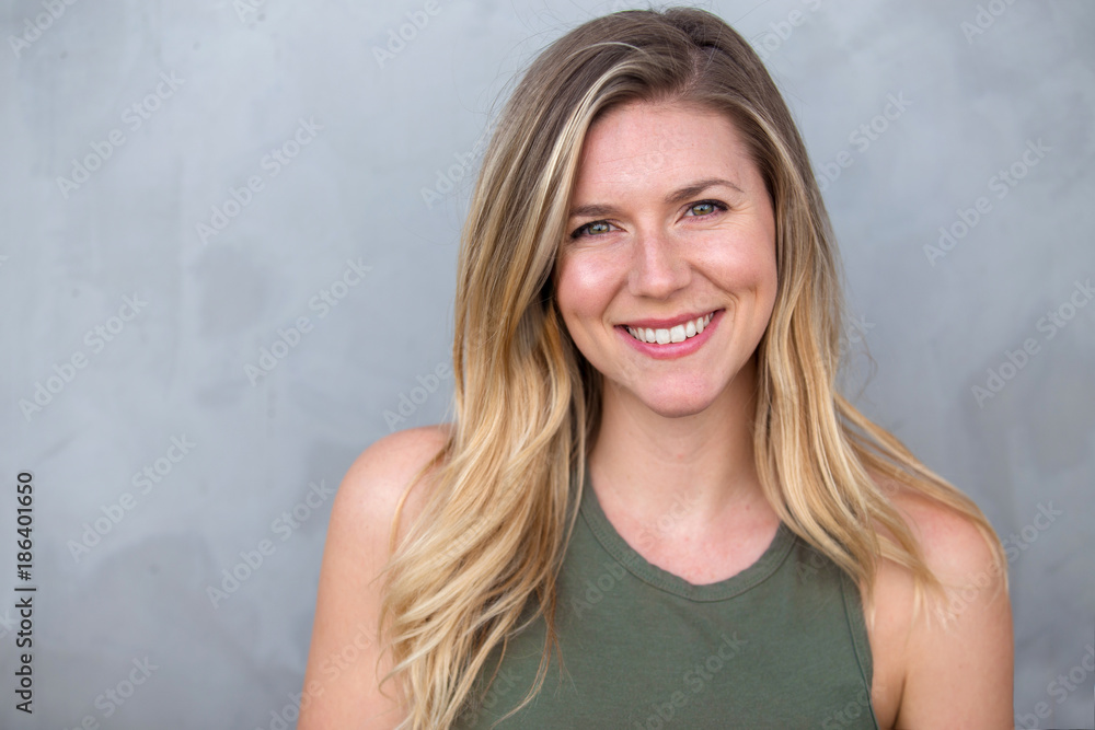 Cute natural blonde woman smiling with perfect white teeth and glowing skin